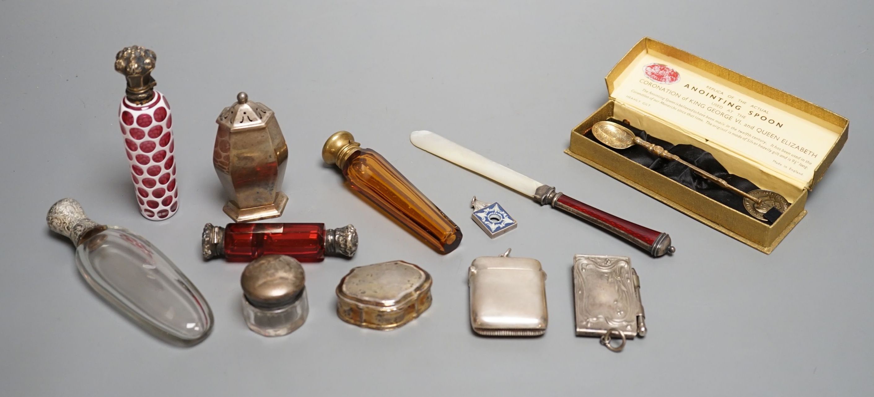 Four assorted white of gilt metal mounted glass scent bottles, largest 12.2cm, an unusual gilt white metal snuff box?, with spoon, a sterling and enamel mounted mother of pearl paper knife and other minor items.
